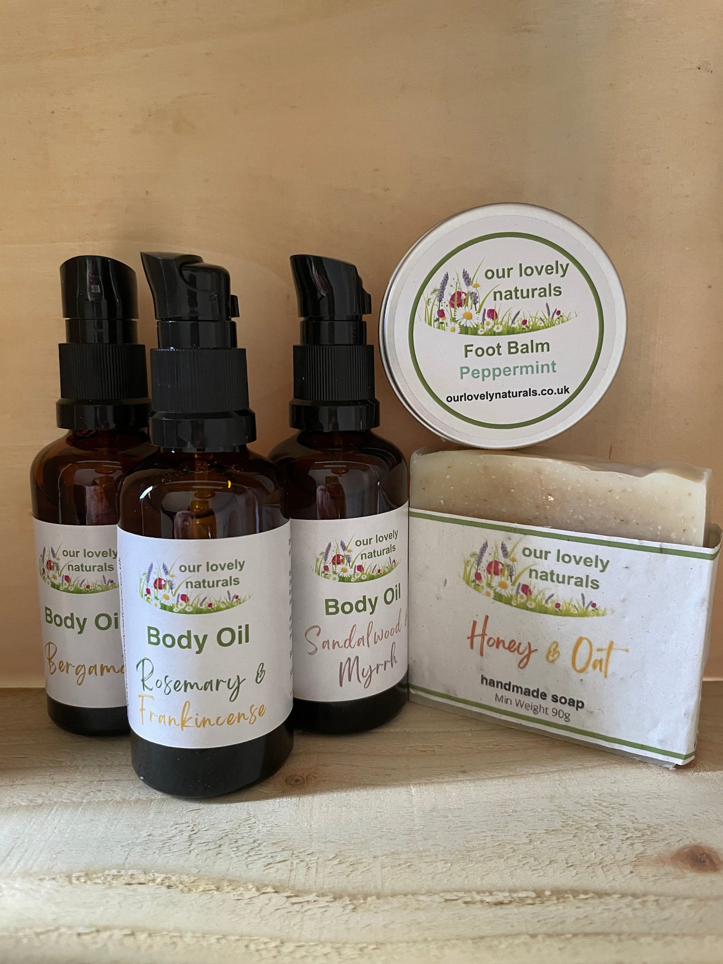 Collection of natural skincare products including bottles and a bar on a wooden surface.