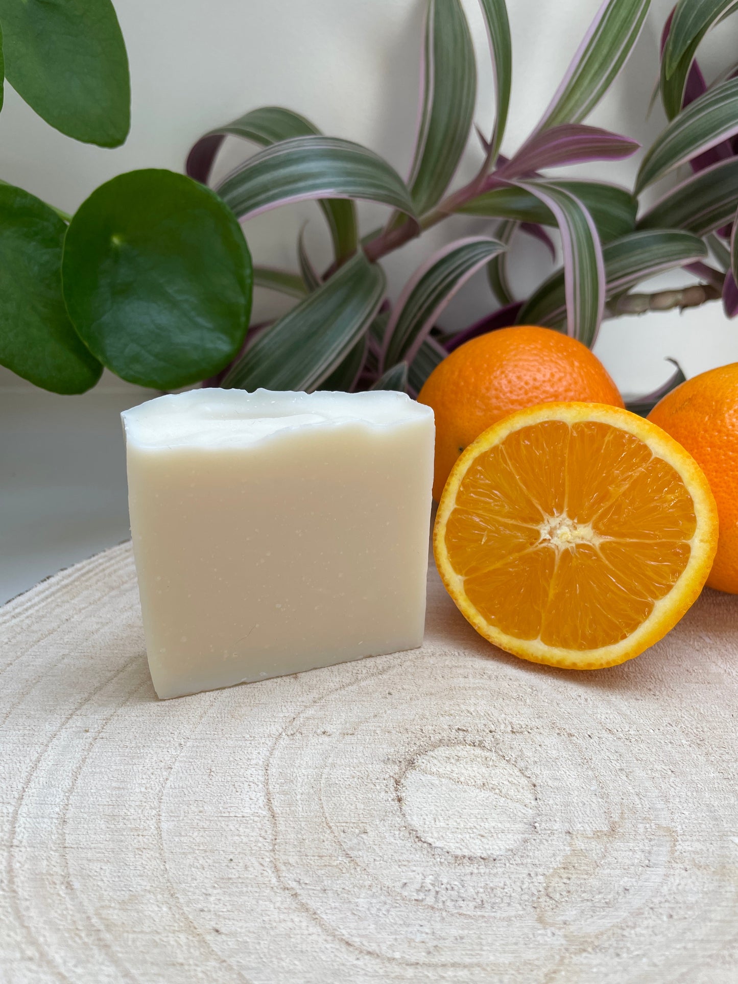 Natural environmentally handmade Sweet Orange, Ylang Ylang & Patchouli Soap bar displayed with sliced oranges.