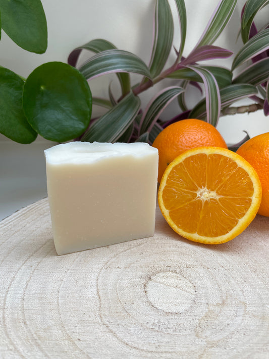 Natural environmentally handmade Sweet Orange, Ylang Ylang & Patchouli Soap bar displayed with sliced oranges.