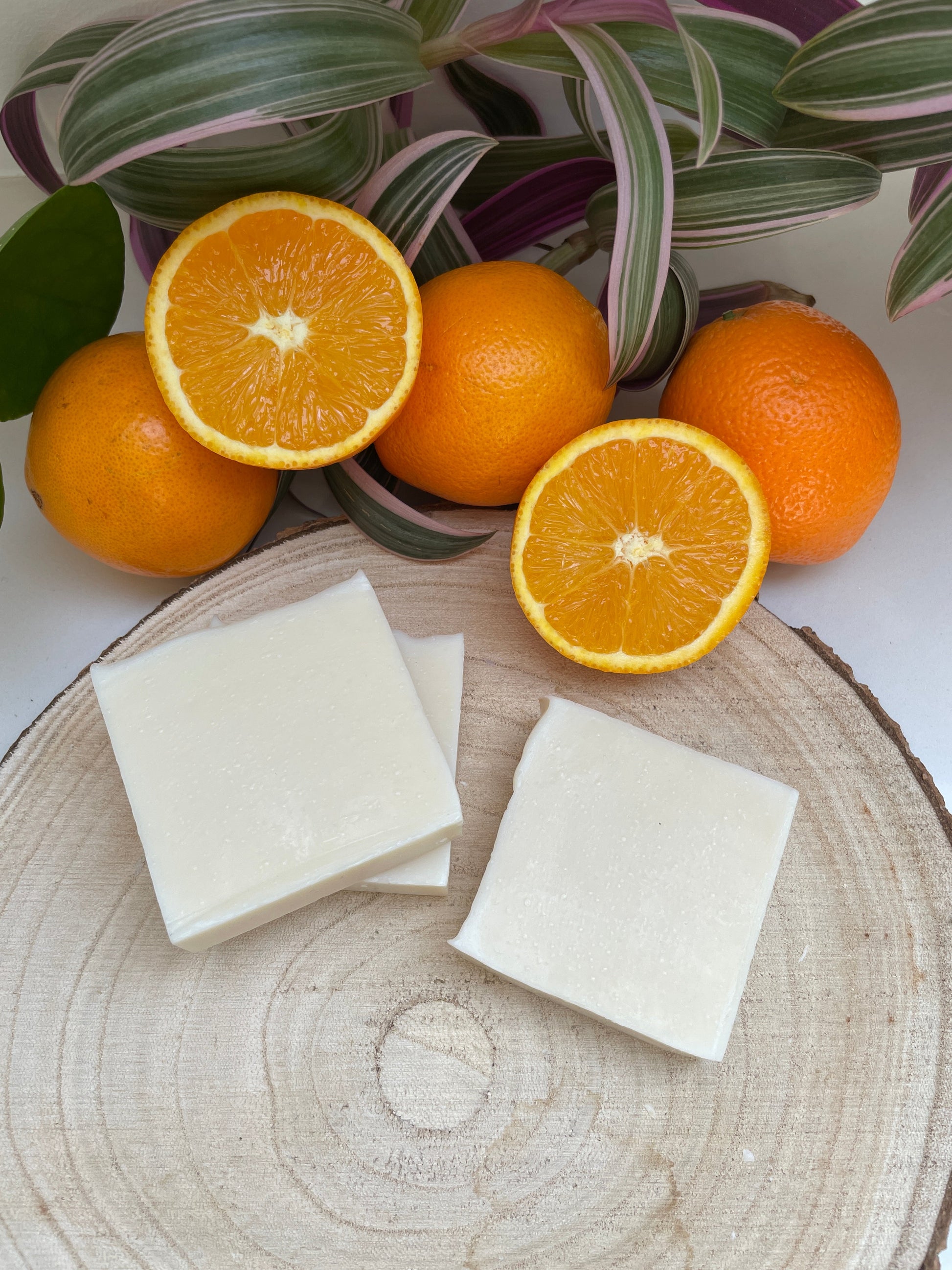 Bars of Sweet Orange, Ylang Ylang & Patchouli Soap bar viewed from above with sliced oranges.